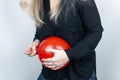 Conceptual photography. The woman holds a red ball near his belly, which symbolizes bloating and flatulence. Then she brings a nee
