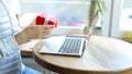 A woman holds a red gift box with a white ribbon in her hands, opens a gift. Royalty Free Stock Photo