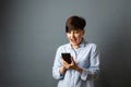 A woman holds and scans the phone, telephone conversation. Woman portrait on a gray background. Copy space