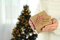 Woman holds Secret Santa gift box, space for text