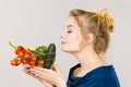 Woman holds shopping basket with vegetables, smelling Royalty Free Stock Photo