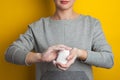 Woman holds and shows soap in her hands. Palms and fingers in soapy foam stretch the soap forward, on a yellow background. Hand Royalty Free Stock Photo