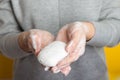 Woman holds and shows soap in her hands. Palms and fingers in soapy foam stretch the soap forward, on a yellow background. Hand Royalty Free Stock Photo