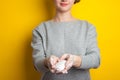 Woman holds and shows soap in her hands. Palms and fingers in soapy foam stretch the soap forward, on a yellow background. Hand Royalty Free Stock Photo