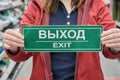 Woman holds sign with the inscription exit in Russian and English. Close up shot Royalty Free Stock Photo