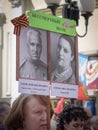 Woman holds sign with pictures of her family dead in the World War II