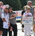 Woman holds sign with Respect is Obeying Our Laws