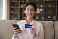 Woman holds smartphone and credit card smile look at camera Royalty Free Stock Photo