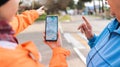 A woman holds a smartphone with an online map and shows the way to an elderly woman with her hand. Mature woman was lost Royalty Free Stock Photo