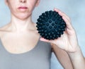 A woman holds a spiky trigger point massage ball used for muscle pain treatment and deep tissue massage Royalty Free Stock Photo