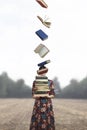 Woman holds a stack of books that take flight free Royalty Free Stock Photo