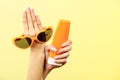 Woman holds sunglasses sunscreen lotion