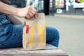 Minsk, Belarus, July 02, 2019: Woman holds takeout packing paper bag with lunch from McDonald`s restaurant in her hand