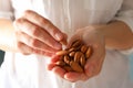 Woman holds tasty almond, close up Healthy eating