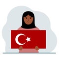 A woman holds a Turkish flag in his hands. Concept for demonstration, national holiday, Turkey day or patriotism