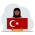 A woman holds a Turkish flag in his hands. Concept for demonstration, national holiday, Turkey day or patriotism