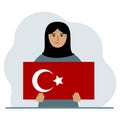 A woman holds a Turkish flag in his hands. Concept for demonstration, national holiday, Turkey day or patriotism