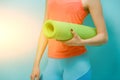 Woman holds twisted fitness mat