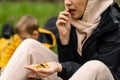 A woman holds various dried fruits and nuts in her hand. Sits on the green grass in the forest. Snack during the hike, walk. Royalty Free Stock Photo