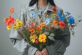 Woman holds a vibrant assortment of wildflowers, embodying spring\'s essence