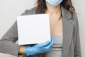 Woman holds a white donation box in protective mask and rubber gloves. Concept of charity volunteer during pandemic of