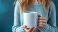 Woman holds white mock up template coffee mug, close up female hands.