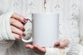 Woman holds white mug in hands. Design Mockup for winter holidays Royalty Free Stock Photo
