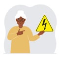 A woman holds a yellow triangular warning sign with a black lightning in his hand. The concept of the danger of electric