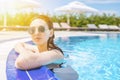 Woman looks out of pool, hanging on the railing. Royalty Free Stock Photo