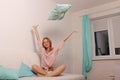 Woman at home in bed having fun and throwing a pillow. Royalty Free Stock Photo