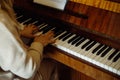 Woman in home clothes sitting at piano, pressing chord and playing musical composition top view closeup. Lady practice