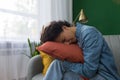 Woman at home crying sitting on sofa hugging pillow, Hispanic woman depressed at home Royalty Free Stock Photo