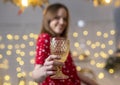 Woman at home decorated for christmas holding glass of wine and cheers close up