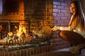 Woman at home fireplace making fire with bellows. Royalty Free Stock Photo