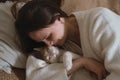 Woman at home holding her cat, room interior on the bed Royalty Free Stock Photo