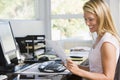 Woman in home office with computer and paperwork Royalty Free Stock Photo