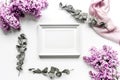 Woman home office with lilic flowers and frame white desk background top view mock up