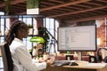 Woman in home office looking at UI on PC display, typing code Royalty Free Stock Photo