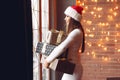 Beautiful girl standing near window with presents Royalty Free Stock Photo