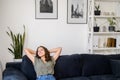 Woman at home, rests on couch at home, leaned back