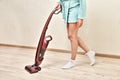 Woman in home robe with handheld vacuum cleaner in hands