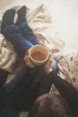 Woman at home sitting in comfy armchair and drinking tea, view from above