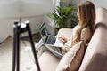woman at home sitting on couch and using laptop with youtube website