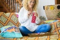 Woman at home sitting on the sofa doing medical protection disposable against coronavirus covid-19 - new hand made work job indoor Royalty Free Stock Photo