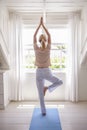 Woman At Home Starting Morning With Yoga Exercises In Bedroom