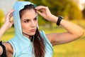 Woman with hooded listening to music from her smart phone Royalty Free Stock Photo