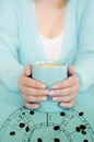 Woman with hooscope and coffee mug in aquamarine coloring