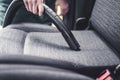 Woman hoovering a car cabin. Vacuum cleaning car seats interior.