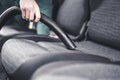 Woman hoovering a car cabin. Vacuum cleaning car seats interior.