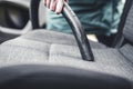 Woman hoovering a car cabin. Vacuum cleaning car seats interior.